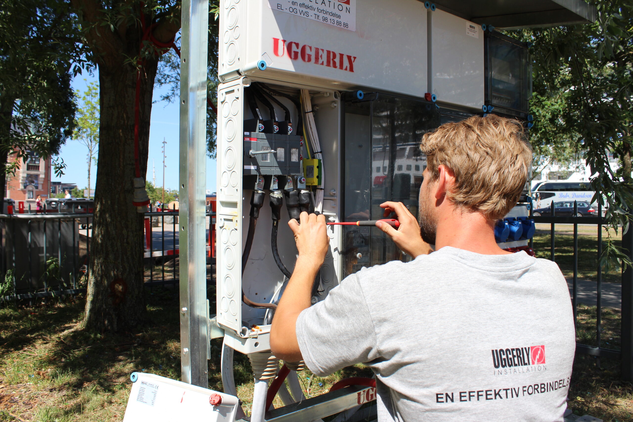 Elektriker tilslutter kabler til eltavle.